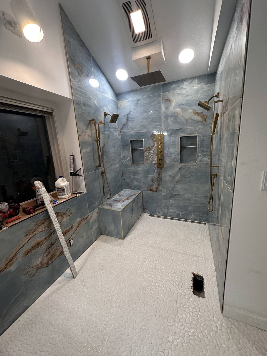 Custom bathroom shower remodel with blue tile and gold fixtures