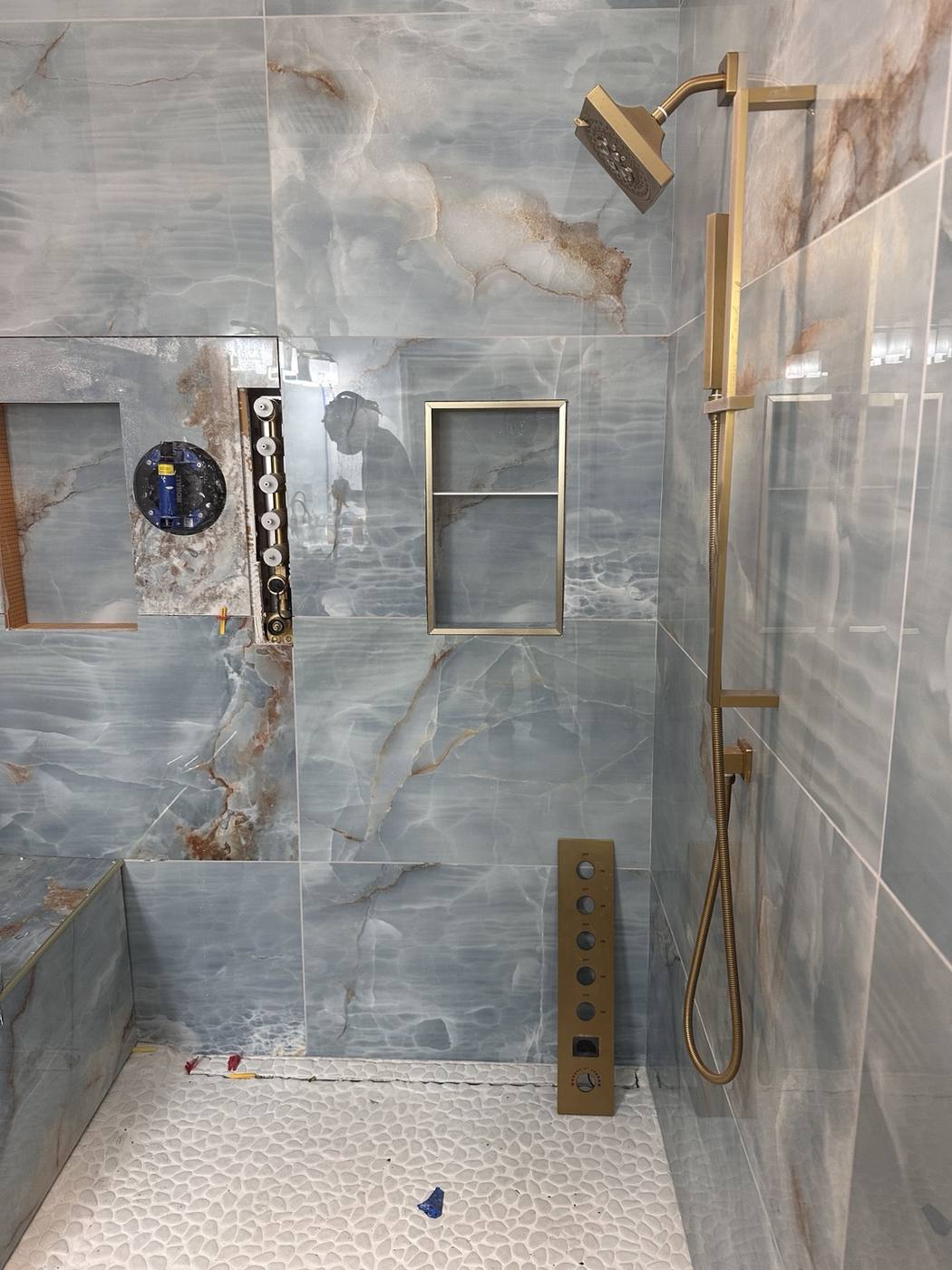 Brushed gold shower fixture and recessed niche detail